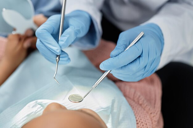 top view closeup of dentist holding tools and mirror while working with child and dental checkup copy space