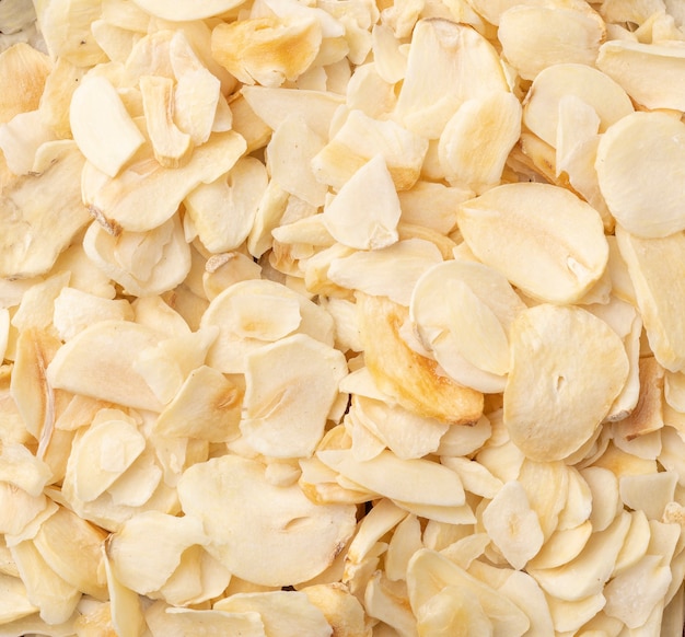 Top view, closeup of dried garlic slices. Food backdrop.