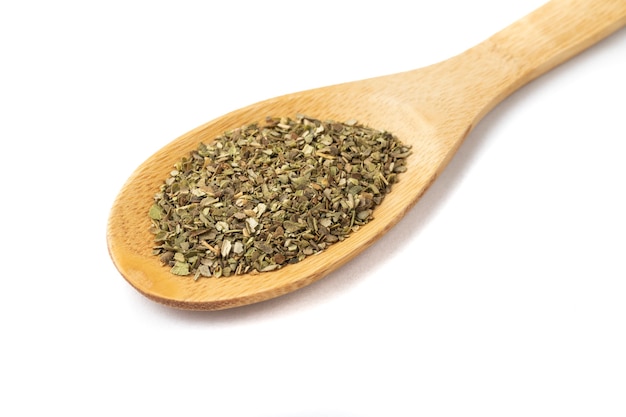 Top view, closeup of dried oregano on a wooden spoon.