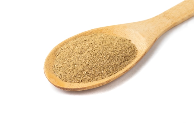 Top view, closeup of ground cumin on a wooden spoon.