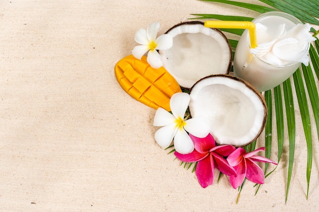 Top view coconut drink on palm leaf at sand beach.