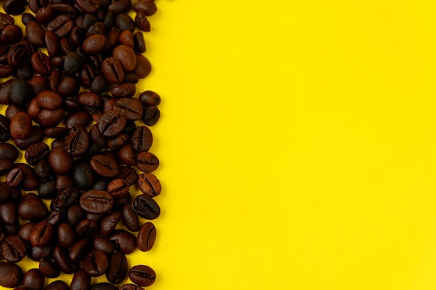 Top view of coffee beans isolated on a yellow background