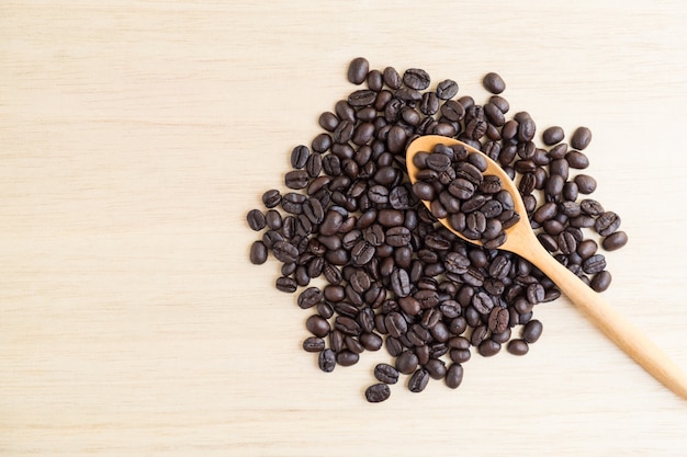 Photo top view of coffee beans and wooden spoon