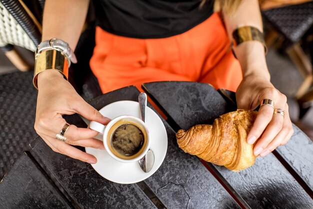 黒いテーブルの上のコーヒーとクロワッサンの上面図。伝統的なフランスの朝食