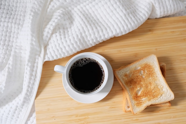 Top view of a coffee cup next to bread toast