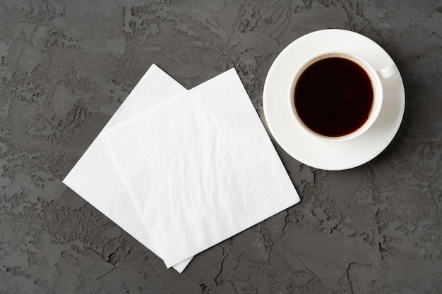 Photo top view of coffee cup and paper napkins on gray background