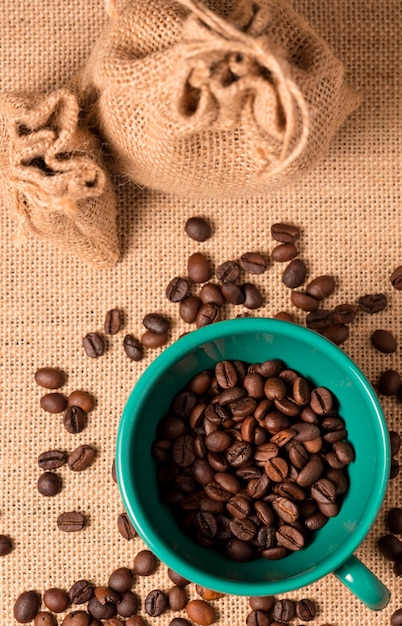 Top view on coffee cup with beans on cloth sacks