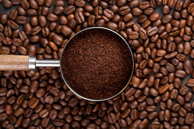 Фото Вид сверху кофейный порошок в ситечке на кофейных зернах