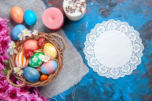 top view colored easter eggs inside basket on blue surface