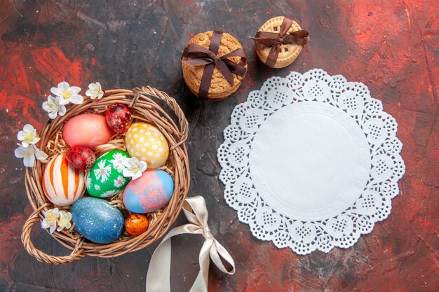 top view colored easter eggs inside basket on dark surface