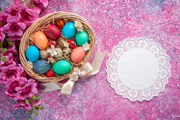 top view colored easter eggs inside basket on pink surface spring colourful concept easter holidays ornate colour