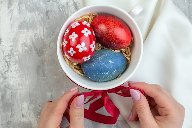 top view colored easter eggs inside cup on white surface