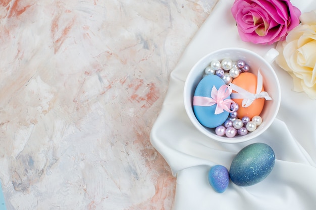 top view colored easter eggs inside cup with beads on a light background horizontal easter ornate spring colourful concept holiday