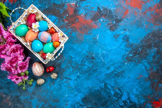 top view colored easter eggs inside cute box on blue surface