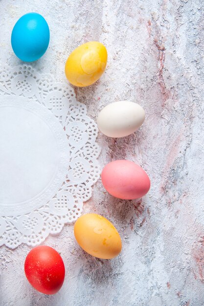 Top view colored easter eggs on white surface