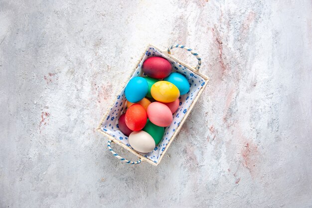 top view colored easter eggs with cute box on white surface