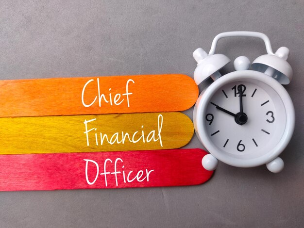 Top view colored ice cream stick and clock with text chief\
financial officer on gray background