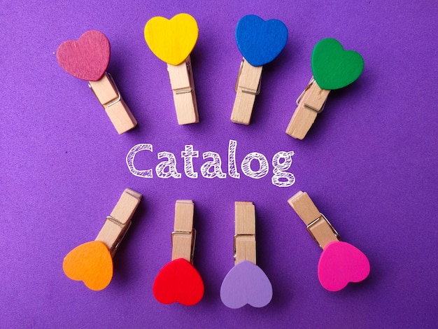 Вид сверху цветные деревянные скрепки слово каталог на фиолетовом фоне