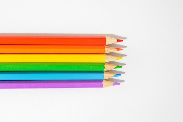 Photo top view of colored wooden pencils, forming colors of the lgbti flag isolated on a white background