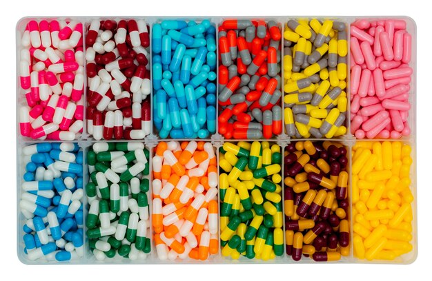 Top view of colorful capsule pills in  plastic box. Antibiotic drugs, painkiller medicine, vitamins, and supplements capsule pills.