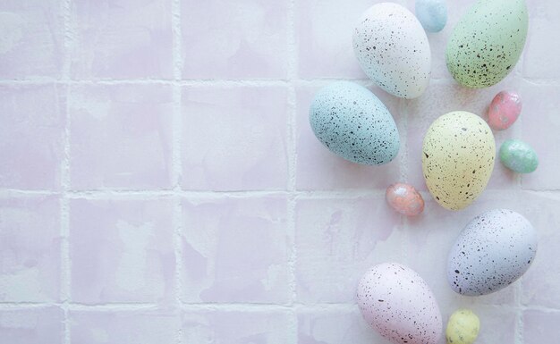 Top view of colorful easter eggs on pink tile background