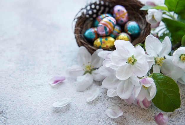 Top view of colorful easter eggs and spring blossom on concrete background