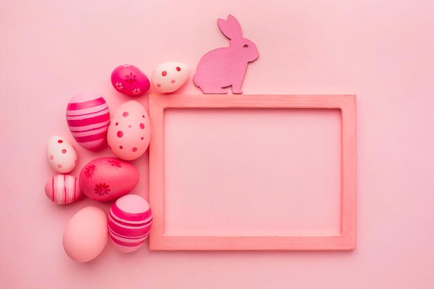 Photo top view of colorful easter eggs with bunny and frame