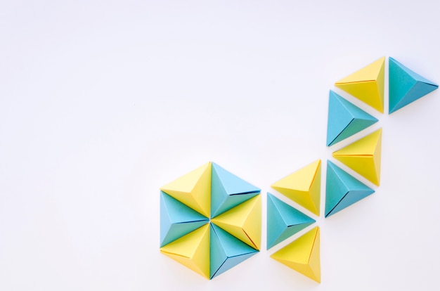 Photo top view of colorful paper pyramids with copy space