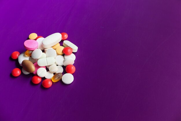 Top view of colorful pills on purple background