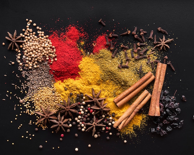 Top view colorful spices on black background