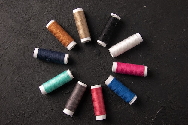 Top view of colorful threads in circle on dark wall