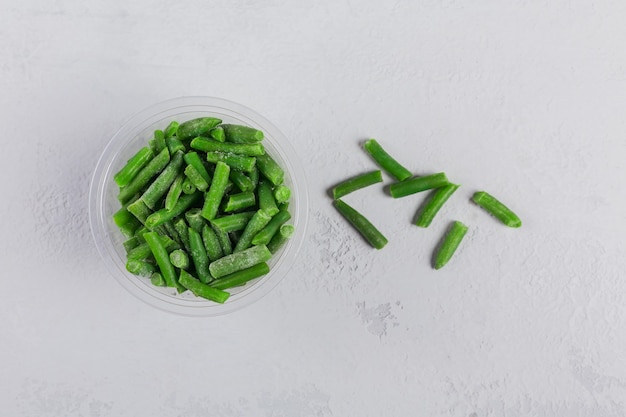 Top view composition with organic frozen vegetables on white concrete table