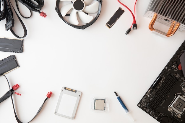 Top view of computer parts and accessories, Electronics repair and upgrade on white desk background, copy space. Motherboard, processor cpu, cooler, radiator, flat lay.