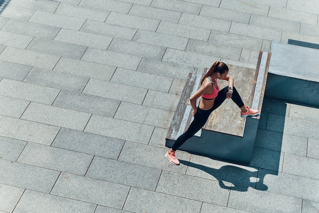 Foto vista dall'alto di una giovane donna sicura di sé in abiti sportivi che si esercita all'aperto