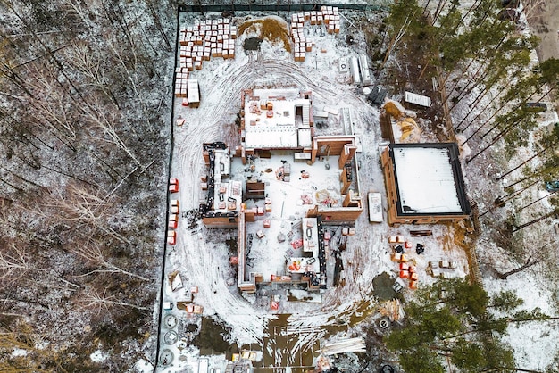 Top view of the construction site Construction of a red brick house Building in winter Detailed shot of the construction site Snow on the construction site