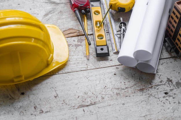 Top view construction tools such as a yellow hard hat spirit level measuring tape