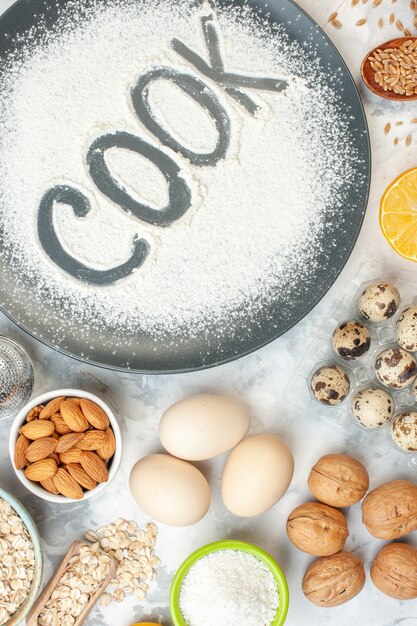 top view cook written flour with cereals eggs seeds nuts and jelly on white surface