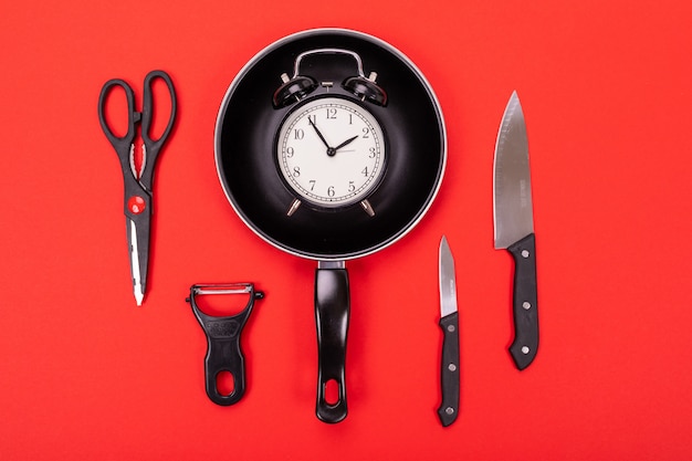 Top view of cooking utensils composition in kitchen isolated on red background