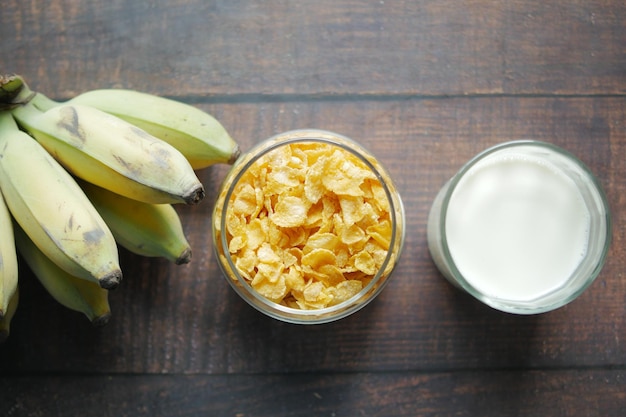 Top view of corn flakes banana and milk on table