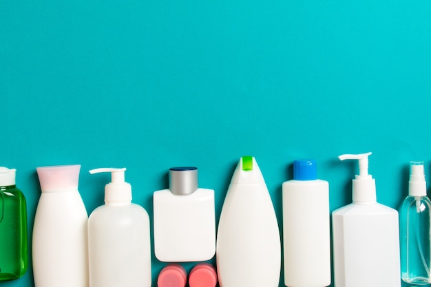 Top view of cosmetics bottles on colored surface