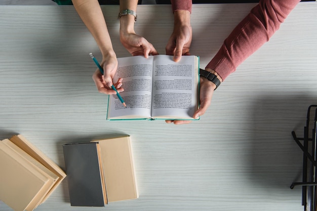 Top view of coworkers holding book in hands