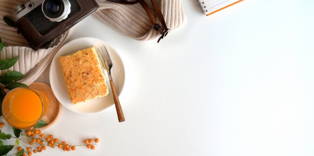 Top view of cozy workspace with a glass of orange juice and toast bread