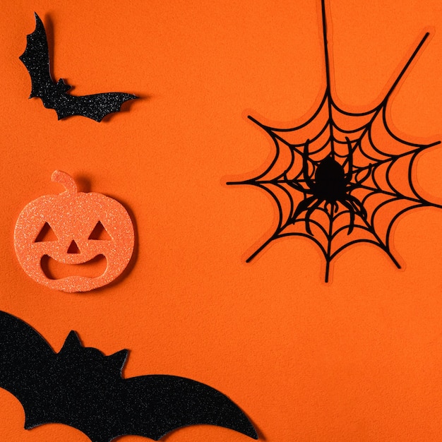 Top view of creative Halloween concept decoration on orange paper table background.