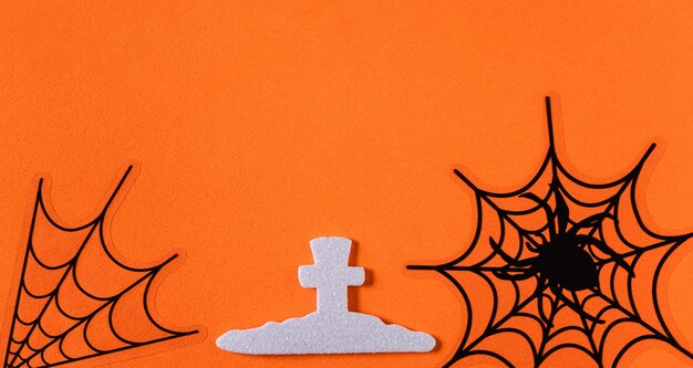 オレンジ色の紙のテーブルの背景に創造的なハロウィーンのコンセプトの装飾の上面図。