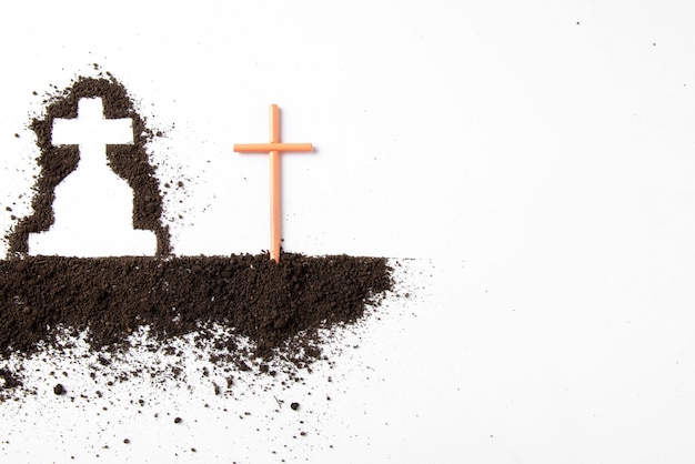 Top view of cross shape with dark soil on white wall