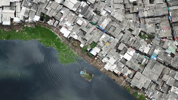 Photo top view of crowded slum neighborhood and an excavator on the lakeside at north jakarta indonesia