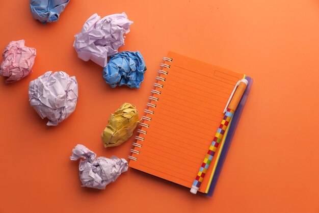 Top view of crumpled paper balls on orange background