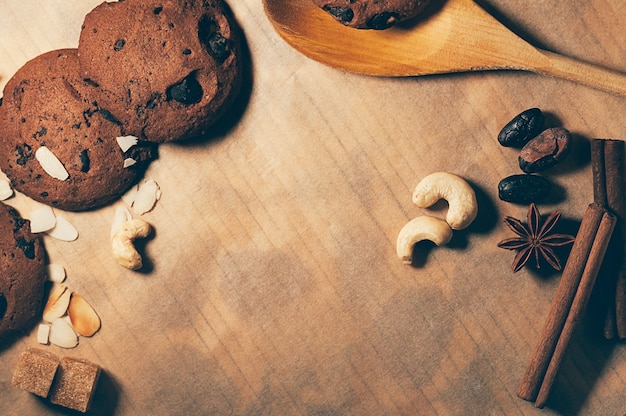 Foto vista dall'alto di croccanti biscotti al cioccolato con noci e spezie su uno sfondo di pergamena strutturata