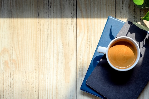 Top view cup of coffee on books with copy space