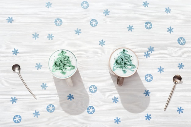 Top view of cup of coffee cappuccino with pattern New Year tree on white wooden table